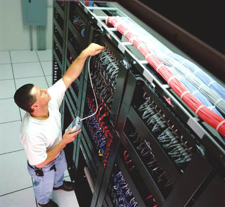 An employee installing Network Cabling in a business 