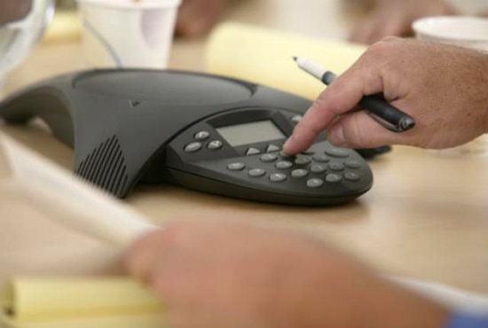 someone dialing on a conference call speaker using voip phone system