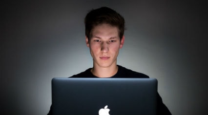 a man studying a laptop computer screen