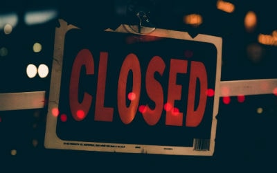 a closed sign hanging on a store door